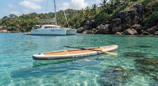 A high-end stand-up paddleboard floating on crystal clear turquoise waters inside a sheltered Sri Lankan cove near Weligama